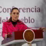 President Sheinbaum gestures while speaking from the podium of her morning press conference