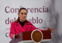 President Sheinbaum gestures while speaking from the podium of her morning press conference