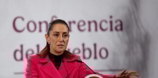 President Sheinbaum gestures while speaking from the podium of her morning press conference