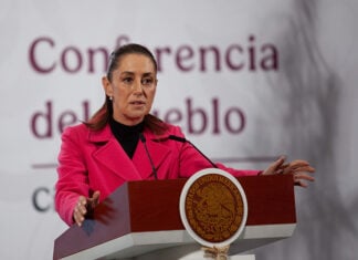 President Sheinbaum gestures while speaking from the podium of her morning press conference