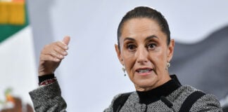 President Sheinbaum gestures as she speaks from behind her press conference podium