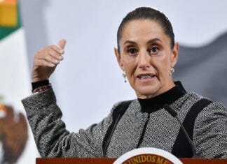 President Sheinbaum gestures as she speaks from behind her press conference podium