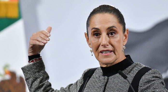 President Sheinbaum gestures as she speaks from behind her press conference podium