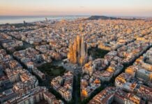Aerial view of Barcelona Eixample residential district and Sagrada Familia Basilica at sunrise.