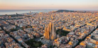 Aerial view of Barcelona Eixample residential district and Sagrada Familia Basilica at sunrise.