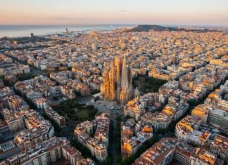 Aerial view of Barcelona Eixample residential district and Sagrada Familia Basilica at sunrise.