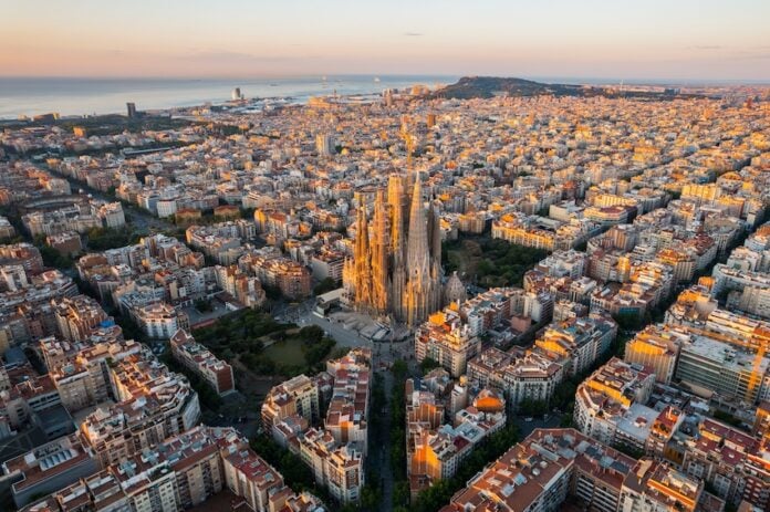 Aerial view of Barcelona Eixample residential district and Sagrada Familia Basilica at sunrise.