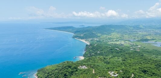 Aerial view of lo de marcos, nayarit, mexico, showcasing the stunning coastline, crystal-clear turquoise waters, sandy beach, and lush green vegetation