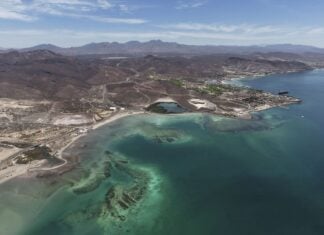 Aerial view of Mexico's rugged coastline with clear turquoise waters and arid mountain terrain in the background
