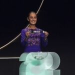 Sheinbaum holds up a small ribbon with the word Mexico at the World Cup draw on Dec. 5