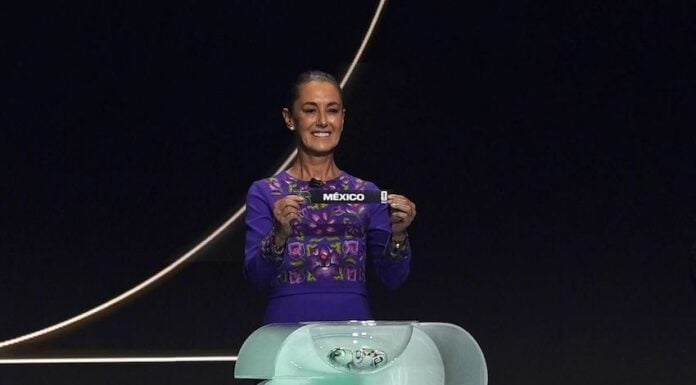 Sheinbaum holds up a small ribbon with the word Mexico at the World Cup draw on Dec. 5