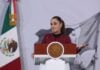 President Sheinbaum smiles and gestures from the podium of her morning press conference