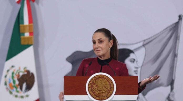 President Sheinbaum smiles and gestures from the podium of her morning press conference