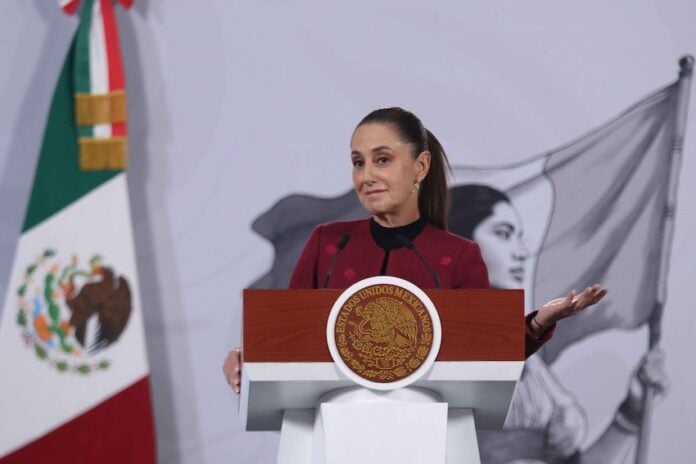 President Sheinbaum smiles and gestures from the podium of her morning press conference