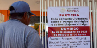 A man reads a sign inviting citizens to participate in the "Consulta Ciudadana sobre el Parque Ecológico y de Reciclaje en Hidalgo"