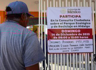 A man reads a sign inviting citizens to participate in the "Consulta Ciudadana sobre el Parque Ecológico y de Reciclaje en Hidalgo"