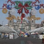 Workers install decorations and structures in the Zócalo for the Winter Lights Festival.