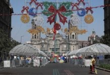 Workers install decorations and structures in the Zócalo for the Winter Lights Festival.