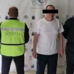 A man in a white shirt under arrest