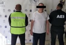 A man in a white shirt under arrest