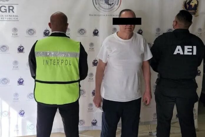 A man in a white shirt under arrest