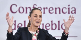 President Sheinbaum gestures from behind the podium of her morning press conference