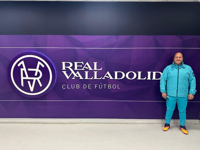 Jalisco ex-governor Enrique Alfaro stands in front of a banner reading Real Valladolid Club de Futbol wearing a sweat suit