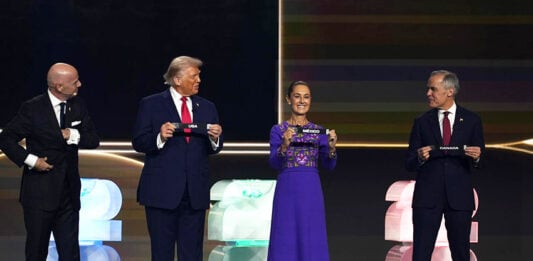 President Sheinbaum on stage next to Trump and Carney, holding a paper reading Mexico