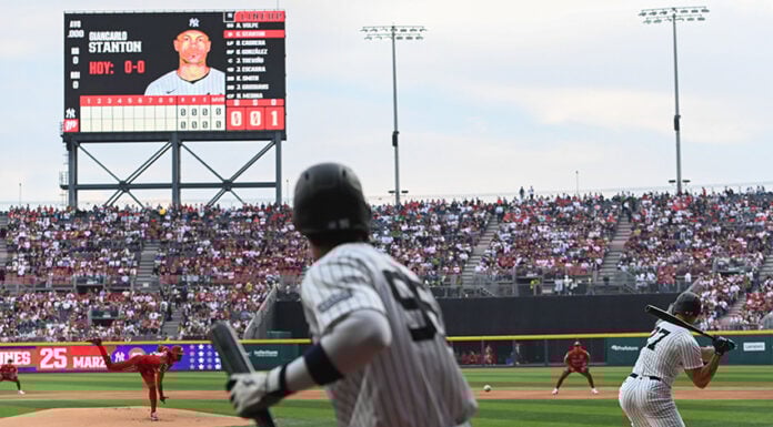 A Yankee batter swings at a baseball thrown by the Mexico City Diablos Rojos pitcher in Alfredo Harp Helú Stadium