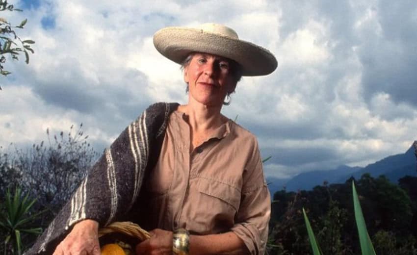 Mexican cuisine authority Diana Kennedy, wearing a traditional Mexican straw hat and sarape posing in front of an agave field in Mexico.