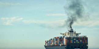 A plume of smoke rises from a cargo tanker at sea