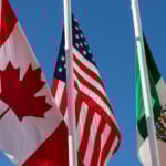 Flags of United States, Mexico, Canada flying together, concept of new NAFTA agreement now known as USMCA in the U.S., CUSMA in Canada or T-MEC in Mexico.