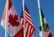 Flags of United States, Mexico, Canada flying together, concept of new NAFTA agreement now known as USMCA in the U.S., CUSMA in Canada or T-MEC in Mexico.