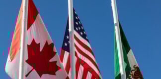 Flags of United States, Mexico, Canada flying together, concept of new NAFTA agreement now known as USMCA in the U.S., CUSMA in Canada or T-MEC in Mexico.