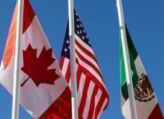 Flags of United States, Mexico, Canada flying together, concept of new NAFTA agreement now known as USMCA in the U.S., CUSMA in Canada or T-MEC in Mexico.