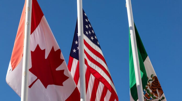 Flags of United States, Mexico, Canada flying together, concept of new NAFTA agreement now known as USMCA in the U.S., CUSMA in Canada or T-MEC in Mexico.