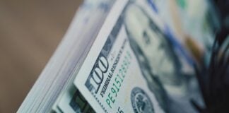 Cash counting machine counts hundred dollar bills