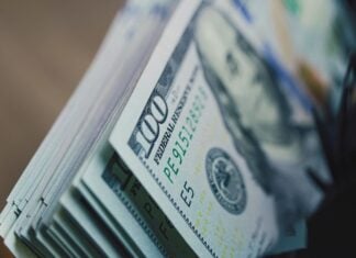 Cash counting machine counts hundred dollar bills