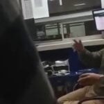 A customs agent gestures in a blurry video screenshot