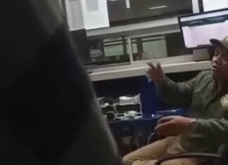 A customs agent gestures in a blurry video screenshot