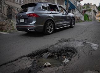 a car avoiding a pothole on a street in Mexico