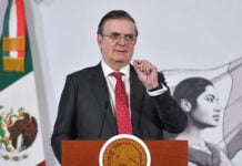 Economy Minister Marcelo Ebrard gestures from a press conference podium