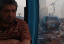A man looks out over Mexico City from a public transport gondola