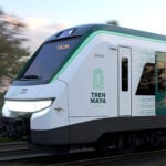 The Maya Train speeds through a forest