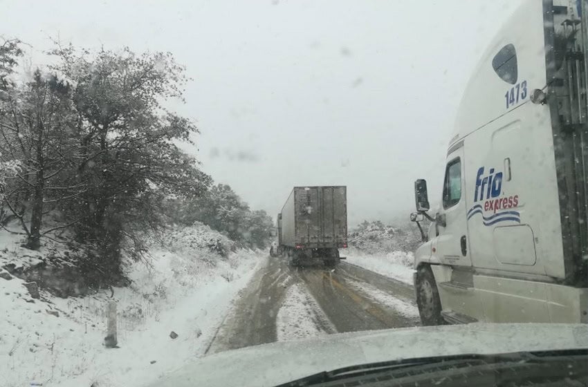Trucks driver through snowy winter weather in northern Mexico