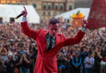 Café Tacvba frontman Rubén Albarrán on stage in a red suit jacket
