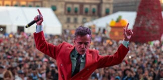 Café Tacvba frontman Rubén Albarrán on stage in a red suit jacket
