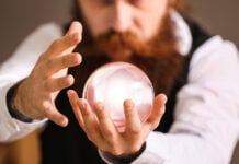 A bearded man stares into a crystal ball