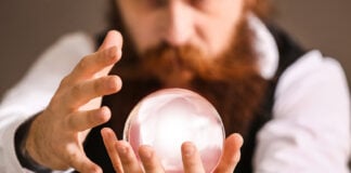 A bearded man stares into a crystal ball