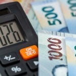 mexican pesos and a calculator with the number 2026